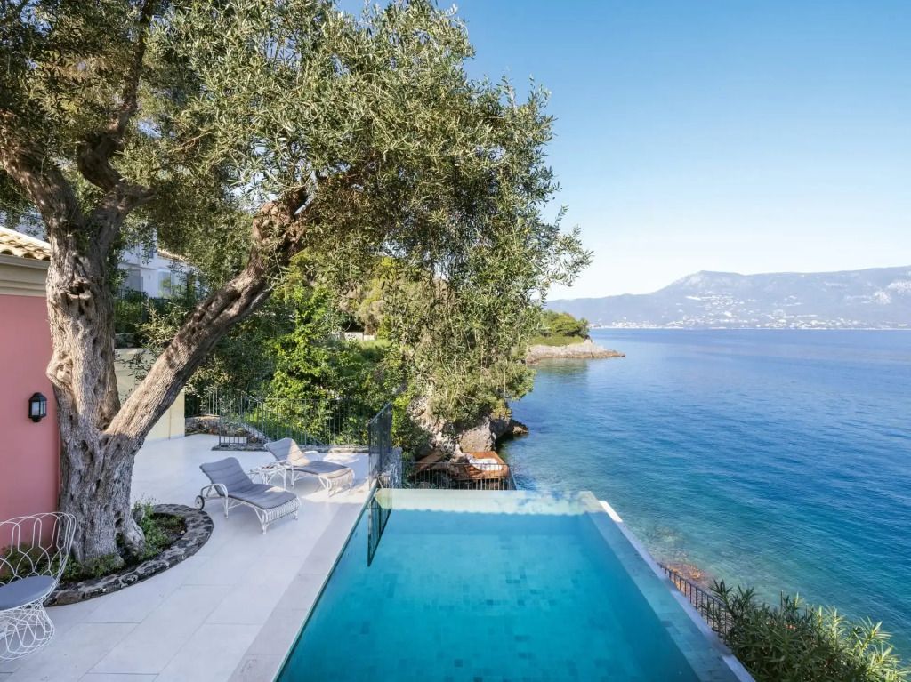 Luxuriöser Pool mit Blick auf das Meer und umgeben von grüner Natur