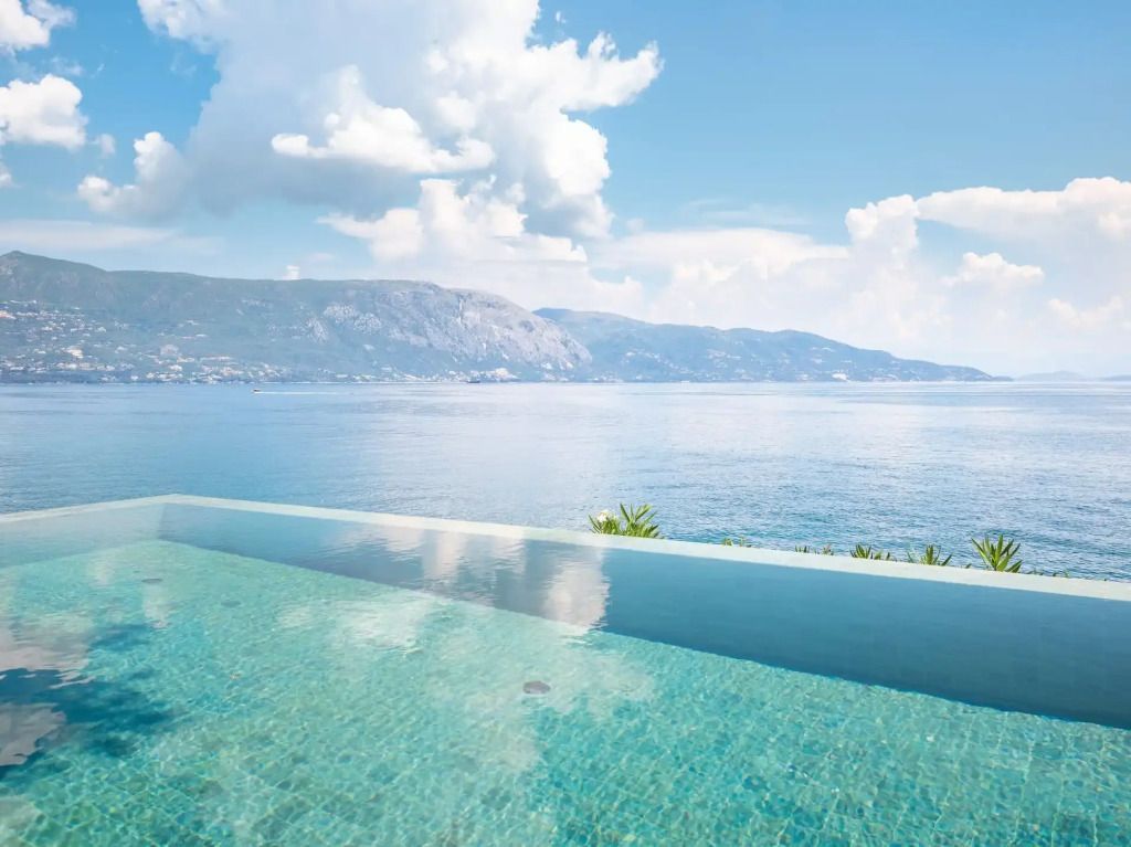Infinity-Pool mit klarer Sicht auf das weite Meer und Berglandschaft