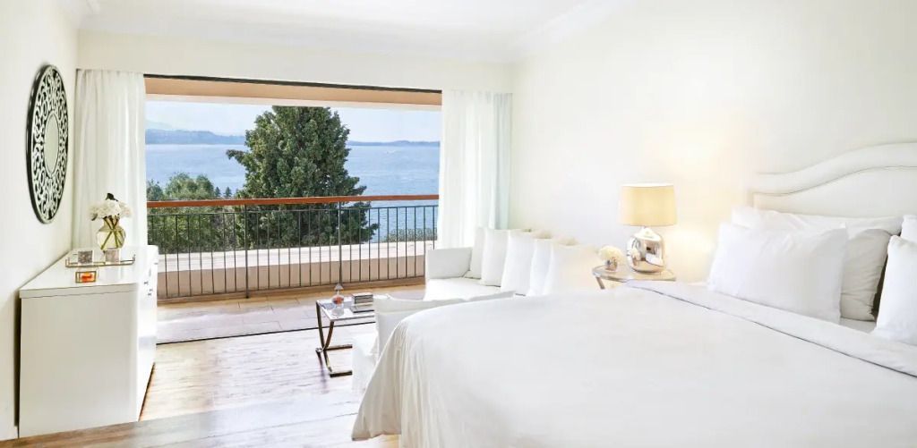 Helles Zimmer mit Meerblick, Balkon und eleganter Einrichtung.