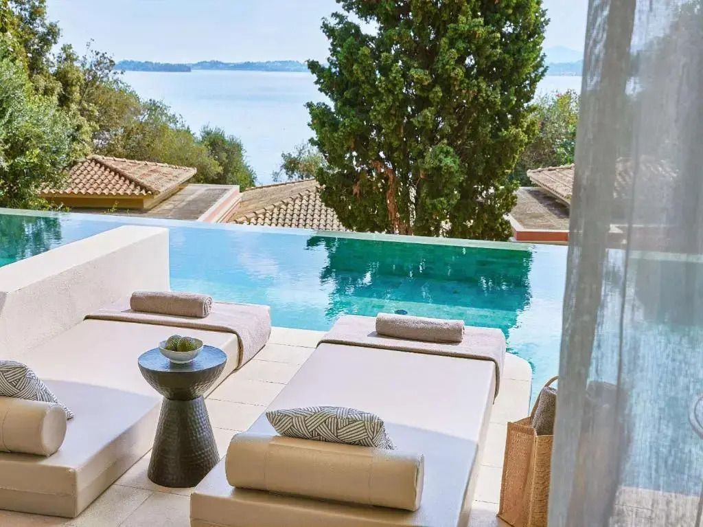 Zwei Liegestühle auf der Terrasse mit Blick auf den privaten Pool und das Meer.