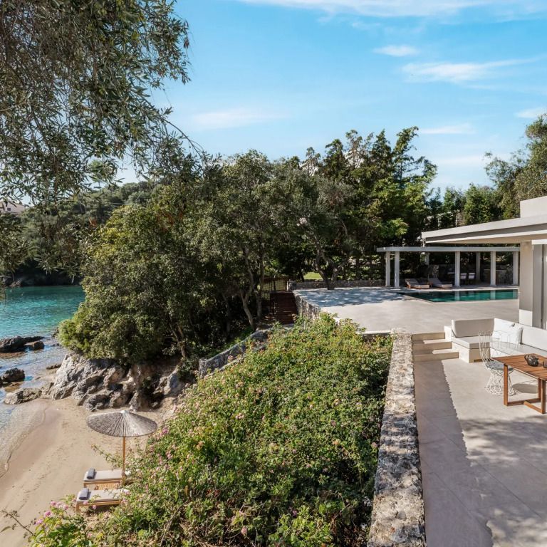Terrasse mit Blick auf den privaten Strand und das blaue Meer.