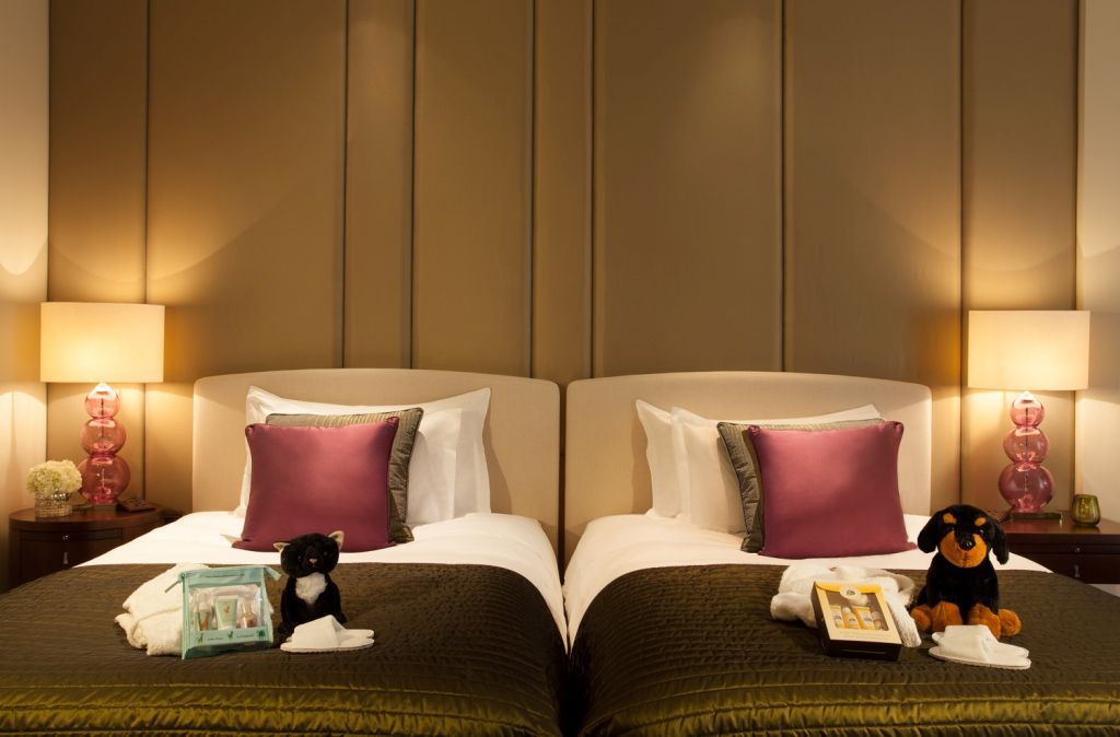 Zwillingsbetten im Corinthia London mit warmen Farben und luxuriösen Kissen