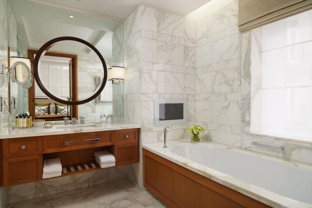 Luxuriöses Badezimmer mit Marmorverkleidung und großer Badewanne