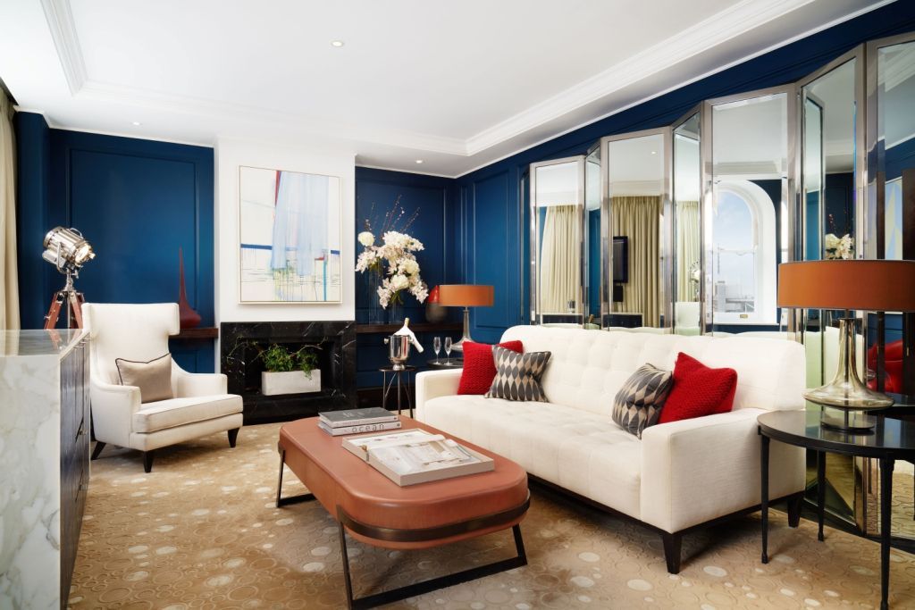 Geräumiges Wohnzimmer mit blauen Wänden und eleganter Dekoration