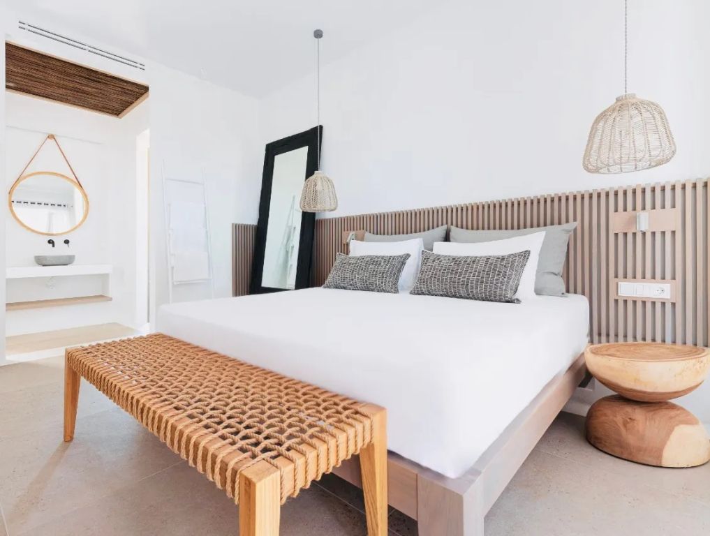 Helles Schlafzimmer mit Doppelbett und stilvollen Details in der Cove Signature Suite.