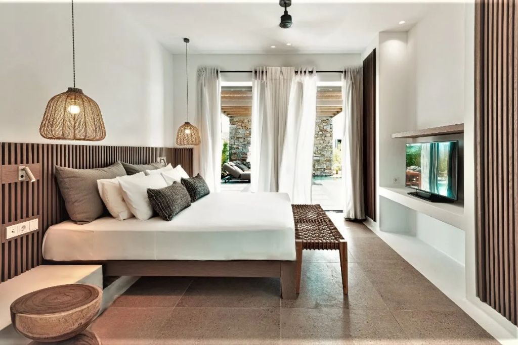 Geräumiges Zimmer mit Doppelbett und Blick auf die Terrasse mit privatem Pool.