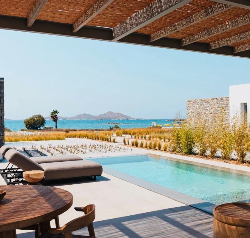 Terrasse mit Infinity-Pool und Meerblick, umgeben von natürlicher mediterraner Landschaft.