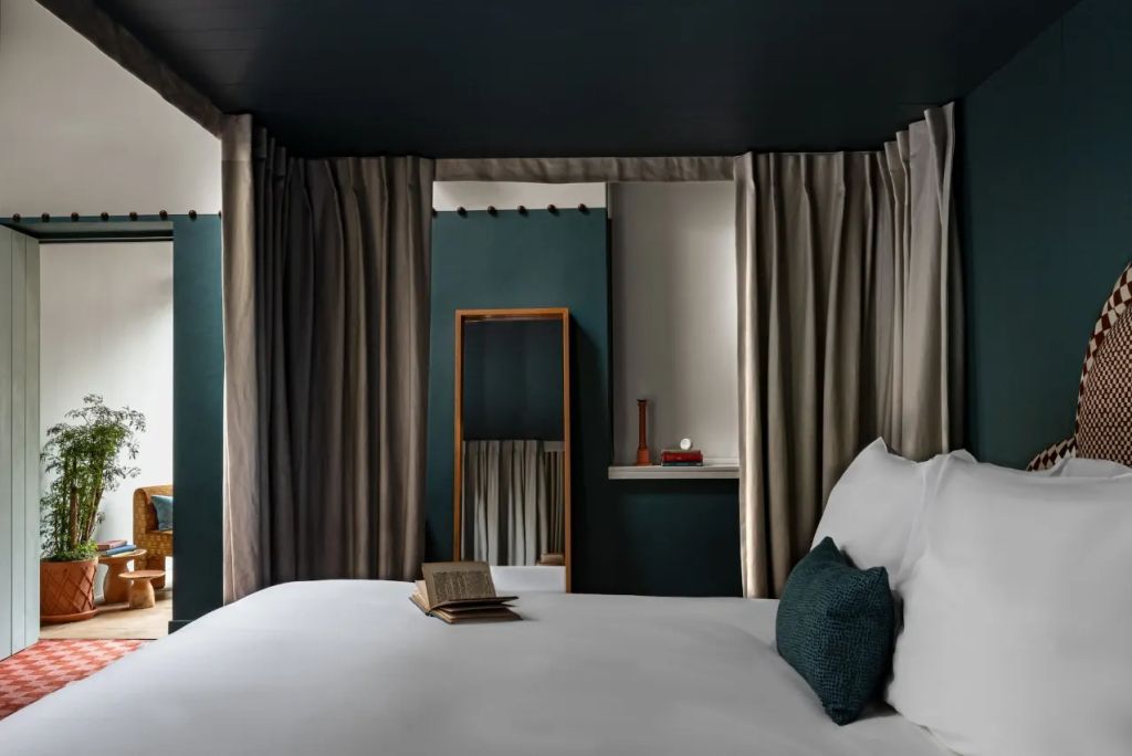 Modernes Doppelzimmer mit eleganten Vorhängen und gemütlichem Doppelbett.