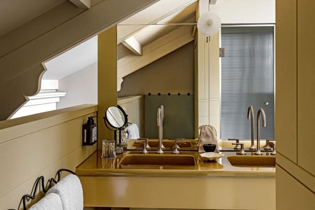 Luxuriöses Badezimmer mit eleganter gelber Waschtischfläche und raffinierter Beleuchtung.