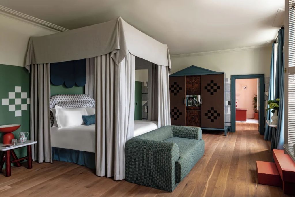 Suite mit Himmelbett, gemütlichem Sofa und großem Kleiderschrank.