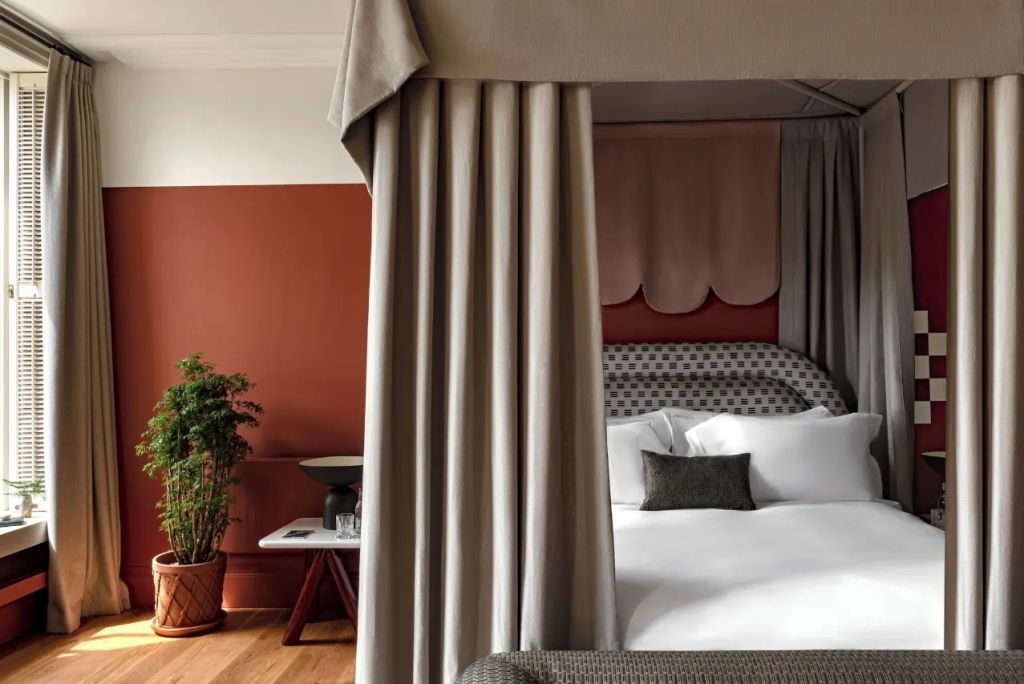 Luxuriöses Doppelbett mit Vorhang in einem stilvoll eingerichteten Hotelzimmer