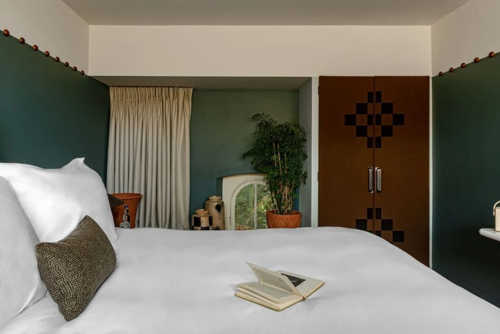 Elegantes Doppelzimmer mit Bett und grüner Wanddekoration