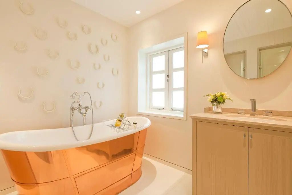 Modernes Badezimmer mit Kupferwanne und Fenster im Superior Stable Zimmer