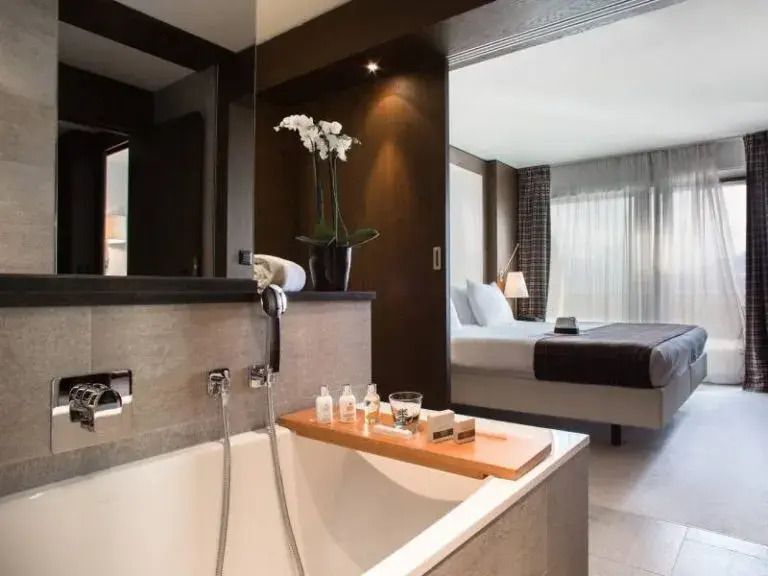 Luxuriöses Badezimmer der Alpina Suite mit freistehender Badewanne und stilvollen Akzenten