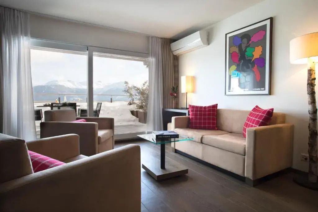 Wohnbereich der Ambassador Suite mit Panoramafenster und stilvollen Möbeln