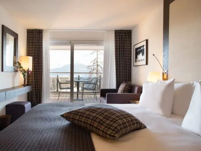 Helles Deluxe Doppelzimmer mit stilvoller Einrichtung und Balkon mit Bergblick