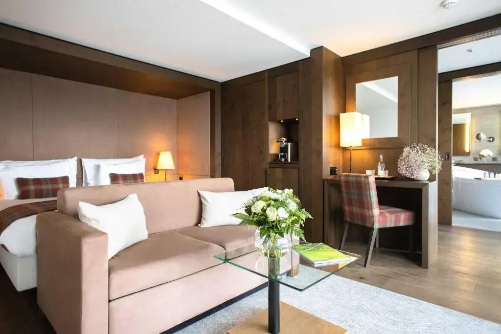 Eleganter Wohnbereich der Deluxe Doppel Suite mit Sofa und Schreibtisch