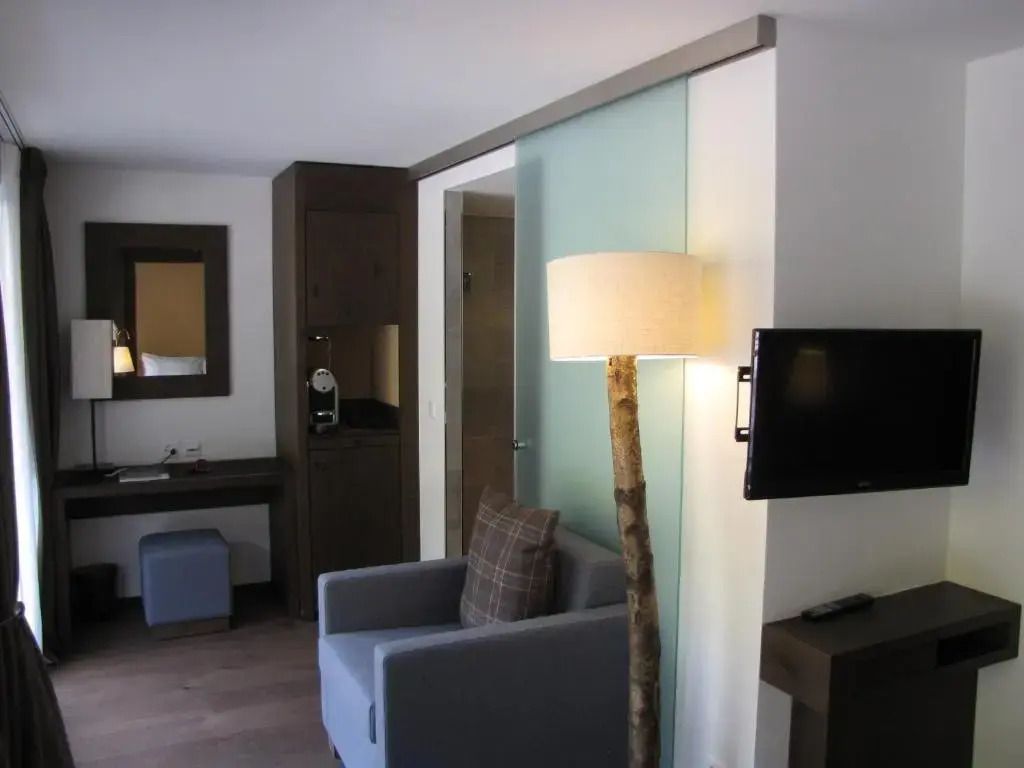 Einzelzimmer im Crans Ambassador mit Schreibtisch, Sessel und TV