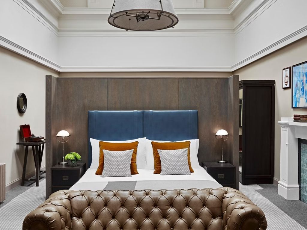 Elegantes Schlafzimmer mit Bett und Ledersofa in der Alba Skylark Suite
