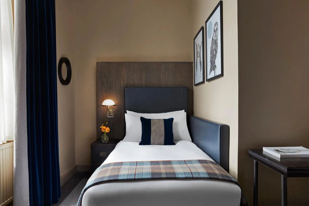Einzelzimmer mit stilvollem Dekor und gemütlichem Bett im Hotel.