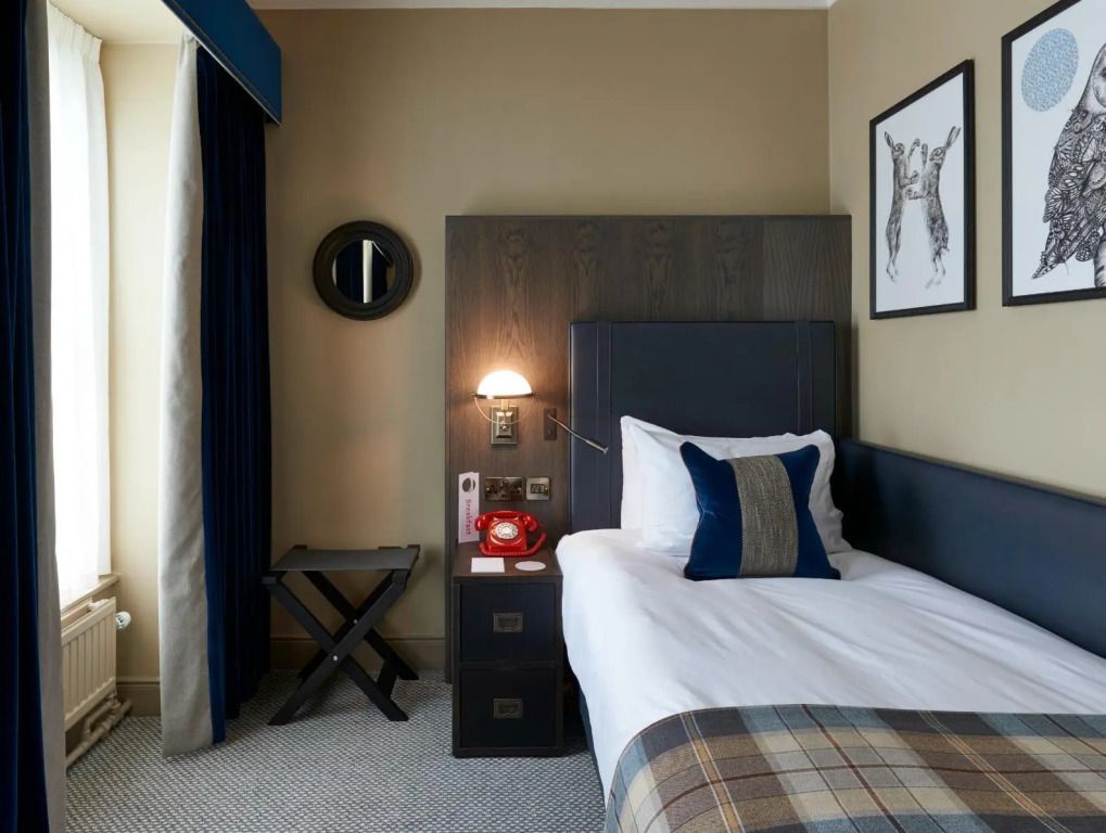 Einzelzimmer mit komfortablem Bett und dekorativem Kissen im Hotel.