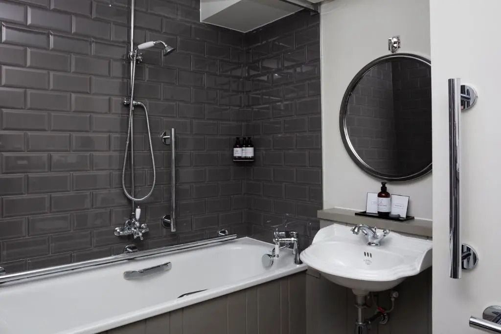 Modernes Badezimmer mit Badewanne und grauen Fliesen