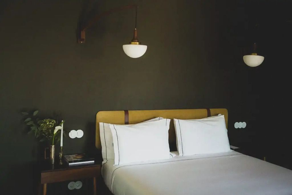 Elegantes Doppelzimmer mit dunkler Wand und stilvollen Leuchten