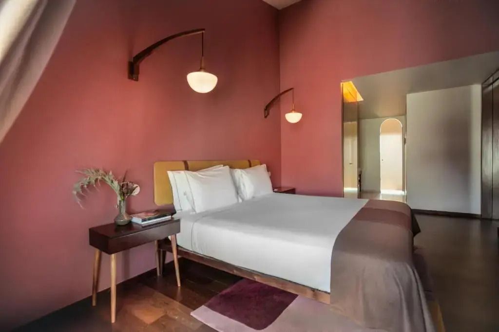 Einladendes Schlafzimmer in warmen Tönen mit weichem Doppelbett und eleganten Lampen.