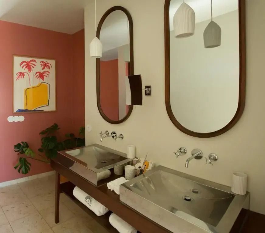 Luxusbadezimmer mit modernen Waschbecken, großen Spiegeln und stilvoller Dekoration.