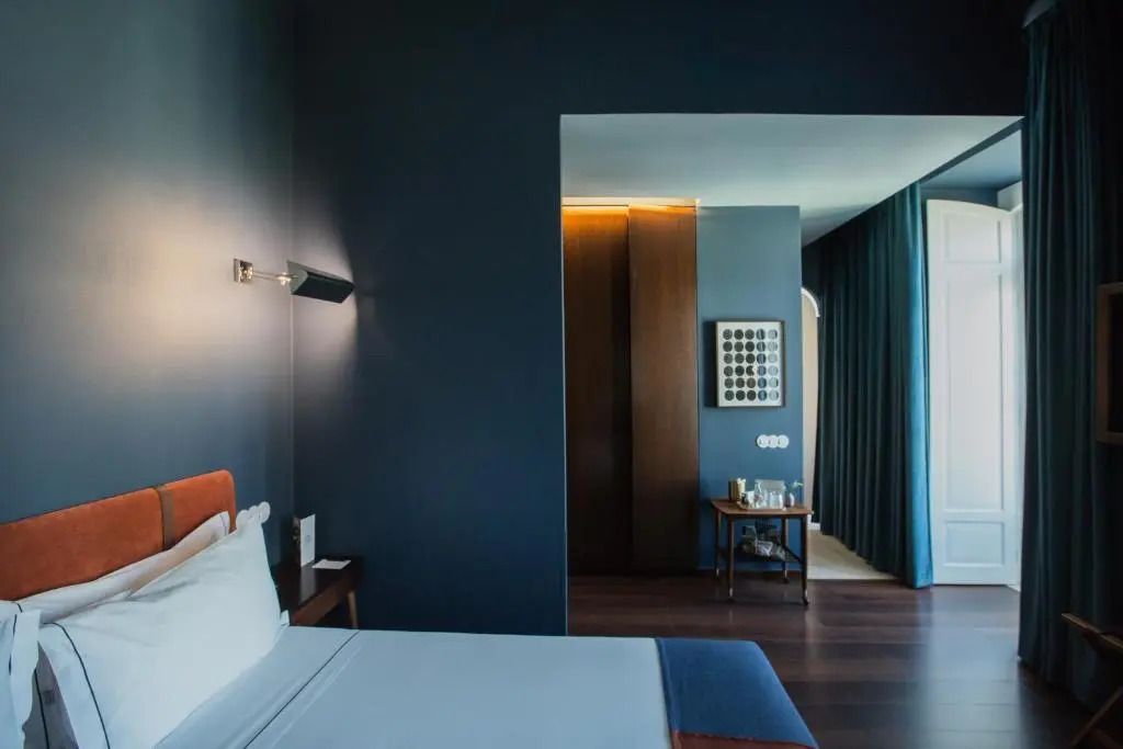 Einladendes Doppelzimmer mit dunkleren Farbtönen und Blick ins Adjacent-Zimmer