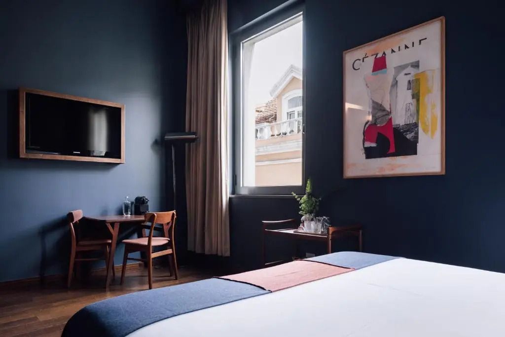 Komfortables Doppelzimmer mit großem Fenster und gemütlichem Sitzbereich