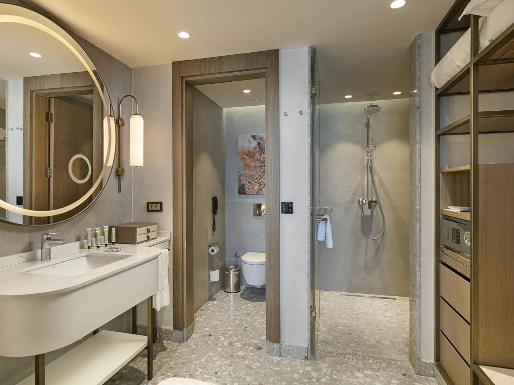 Modernes Badezimmer mit Dusche. Runde Spiegel und dezente Beleuchtung.