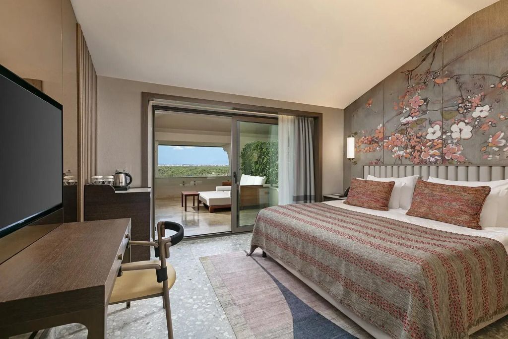 Hotelzimmer mit Doppelbett und großem Balkon mit Ausblick