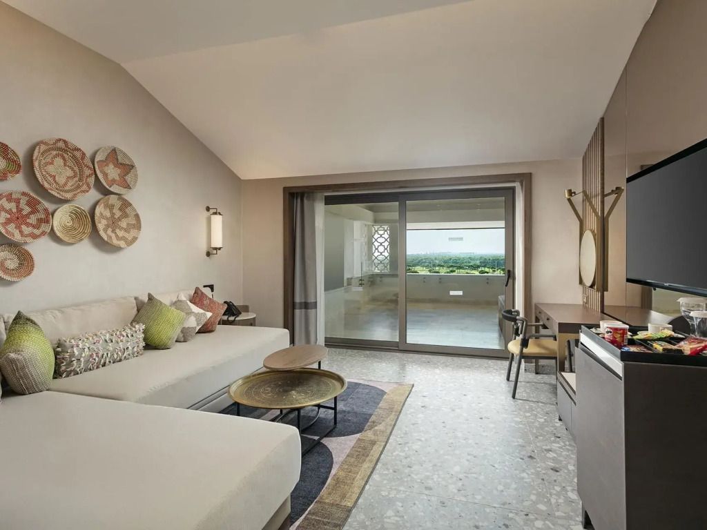 Lounge-Bereich der Suite mit modernen Möbeln und großen Fenstern.