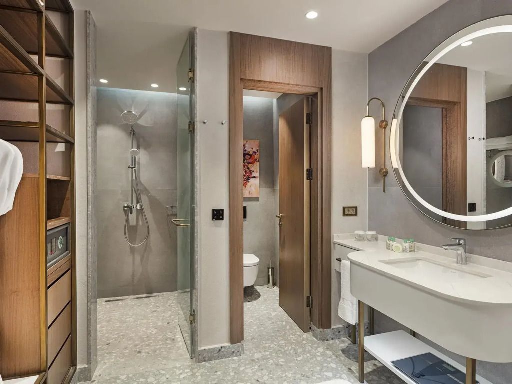 Modernes Badezimmer mit großer Dusche und rundem Spiegel