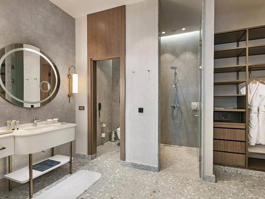 Modernes Badezimmer mit Dusche und rundem Spiegel