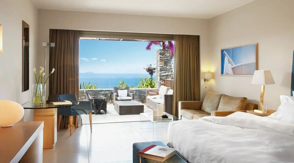 Lichtdurchflutetes Deluxe Doppelzimmer mit Doppelbett und Meerblick Terrasse.