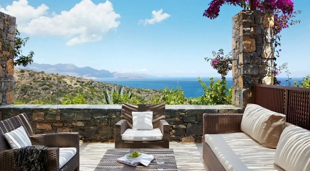 Terrassenbereich mit Sitzgelegenheiten und Panoramablick auf das Meer.