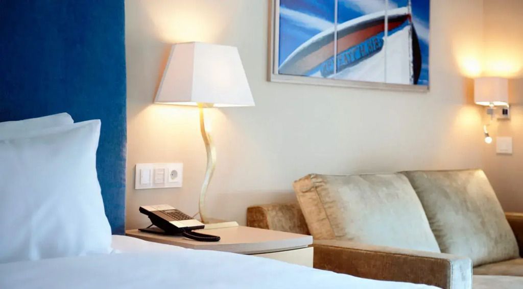 Gemütlicher Wohnbereich mit eleganter Lampe und stilvollem Sofa in der Junior-Suite