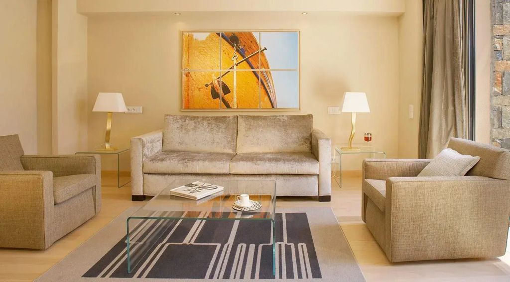 Heller und moderner Wohnbereich mit Sofa und Glastisch in der Junior-Suite