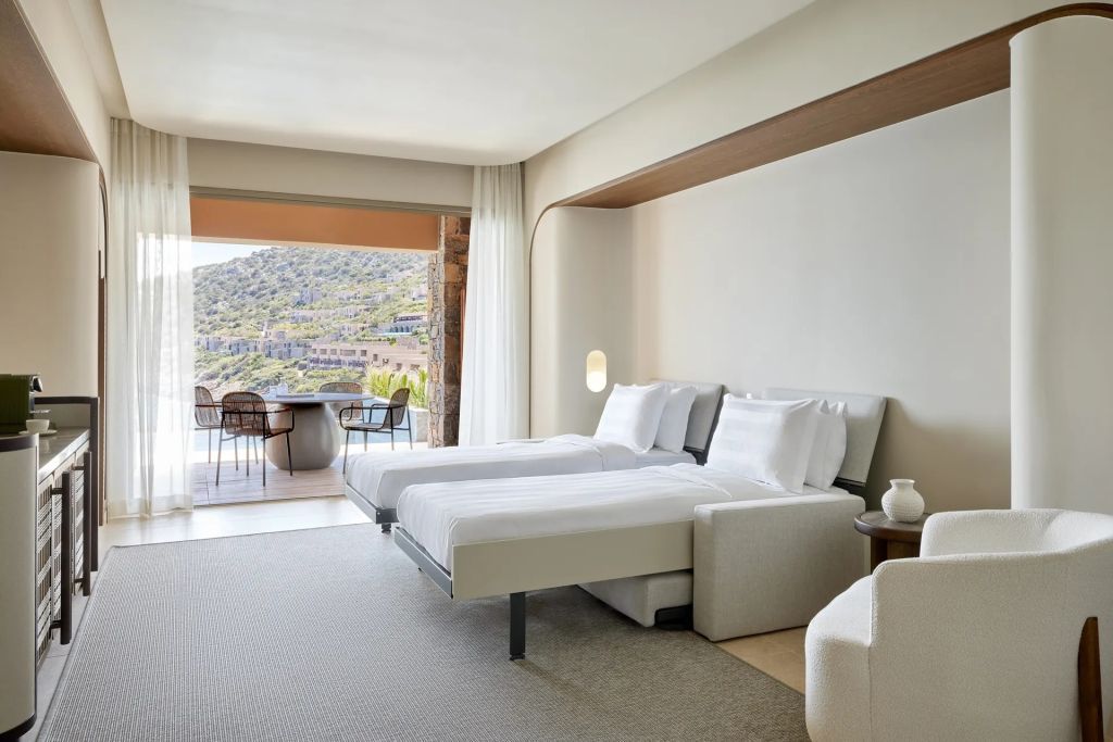 Modernes Schlafzimmer mit zwei Betten und Aussicht auf die Landschaft