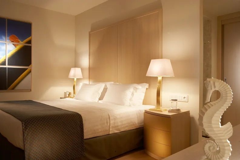 Schlafzimmer mit Doppelbett und warmem Licht von eleganten Tischlampen.