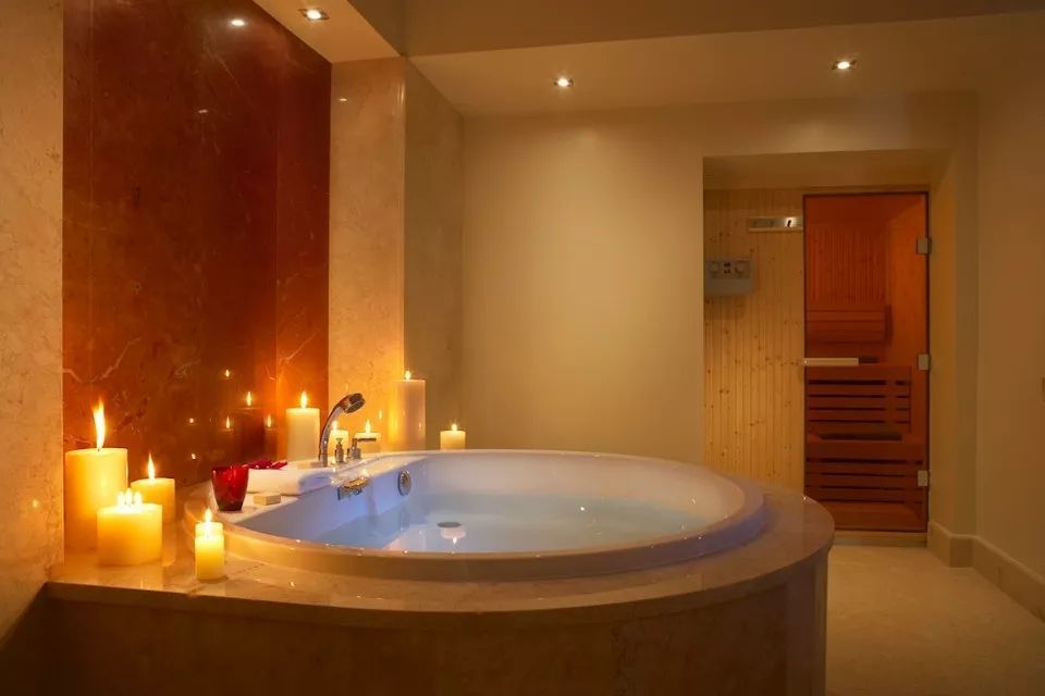 Entspannendes Badezimmer mit großer Badewanne und Kerzenbeleuchtung