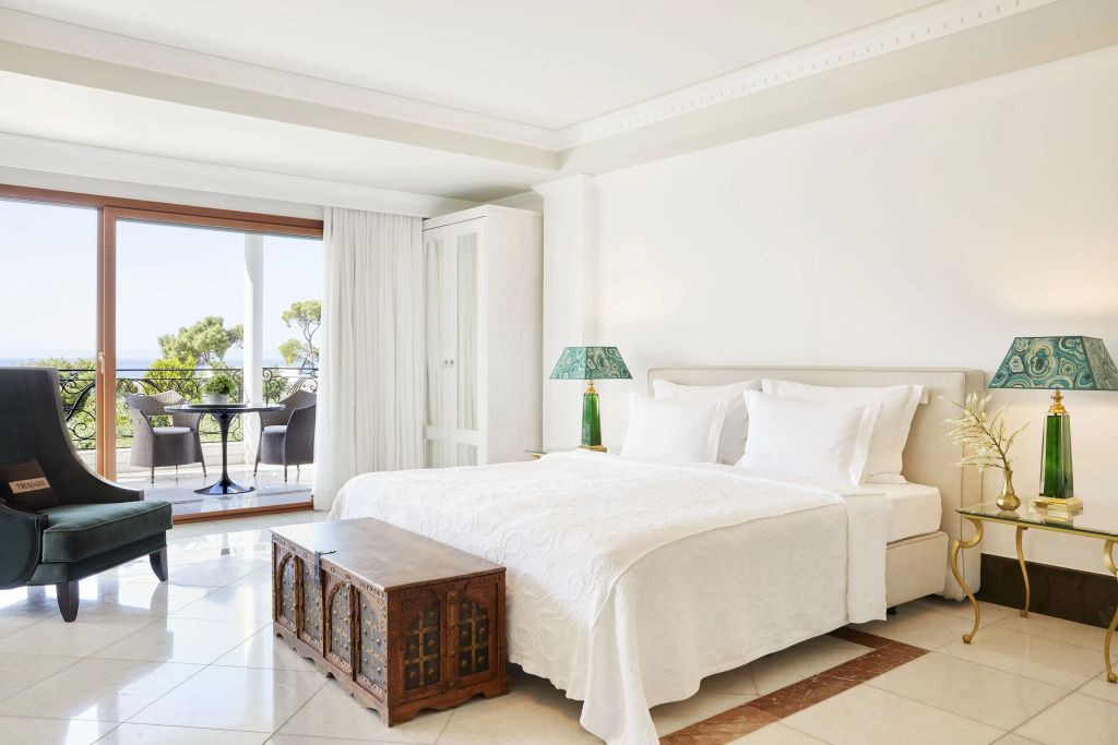 Helles Schlafzimmer mit Doppelbett und Meerblick von der Terrasse