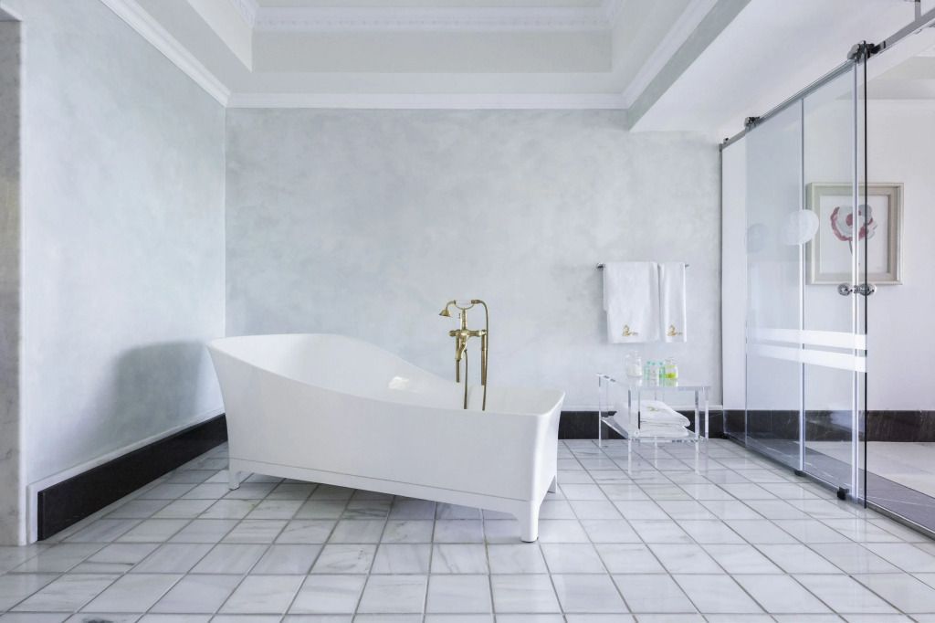 Freistehende Badewanne in modernem Badezimmer mit goldenen Armaturen
