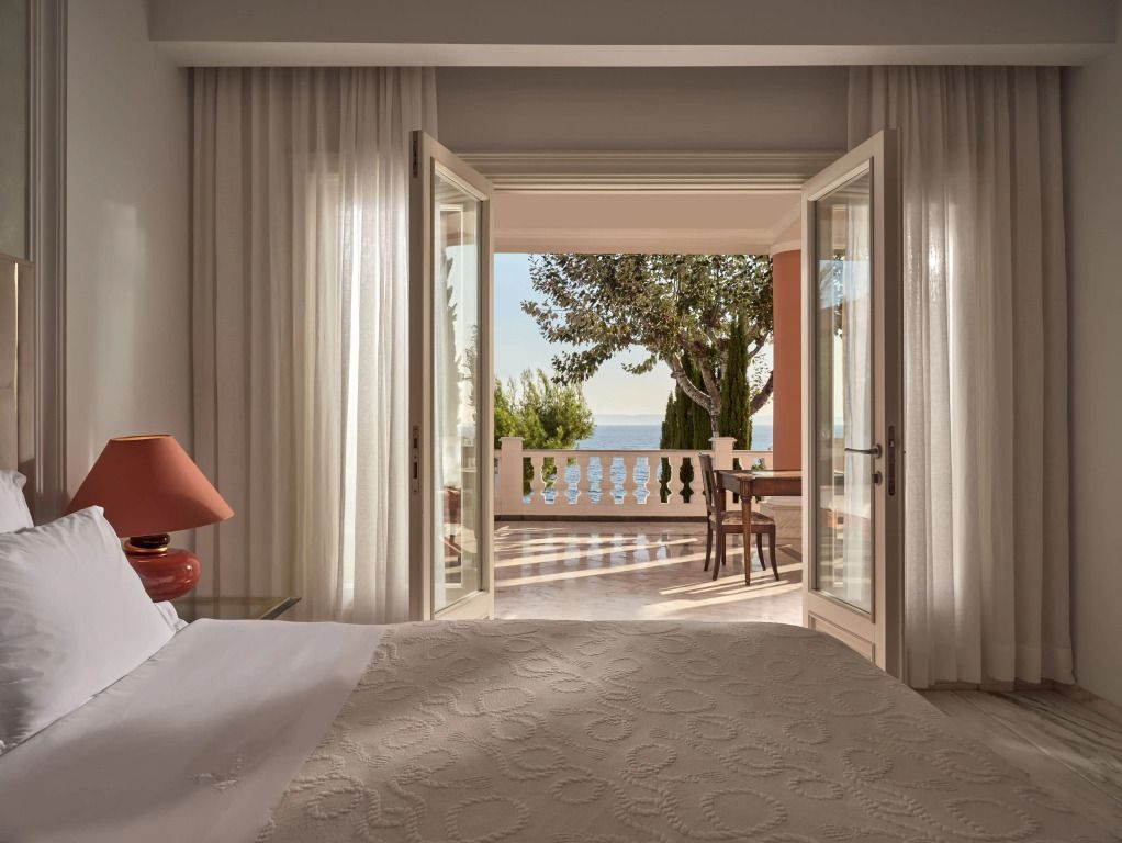 Gemütliches Schlafzimmer mit Blick auf das Meer durch geöffnete Terrassentüren
