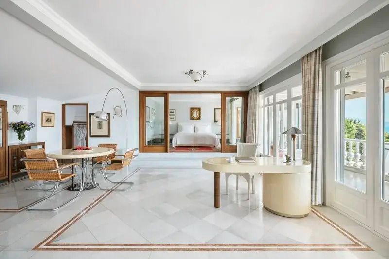 Moderne Suite mit Arbeitsbereich und großem Bett im Hintergrund