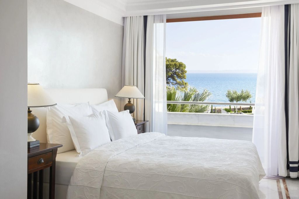 Helles Schlafzimmer mit großem Fenster und Meerblick im The Danai Hotel