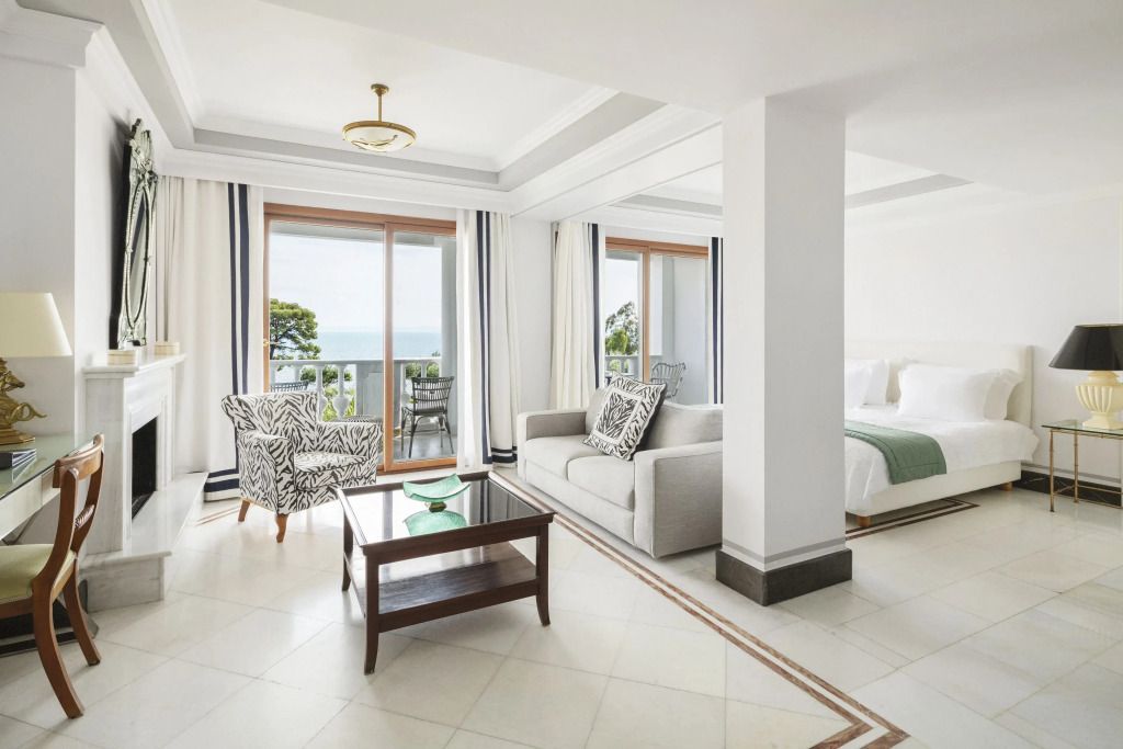 Wohnbereich mit Sofas und Zugang zu einem Balkon mit Meerblick