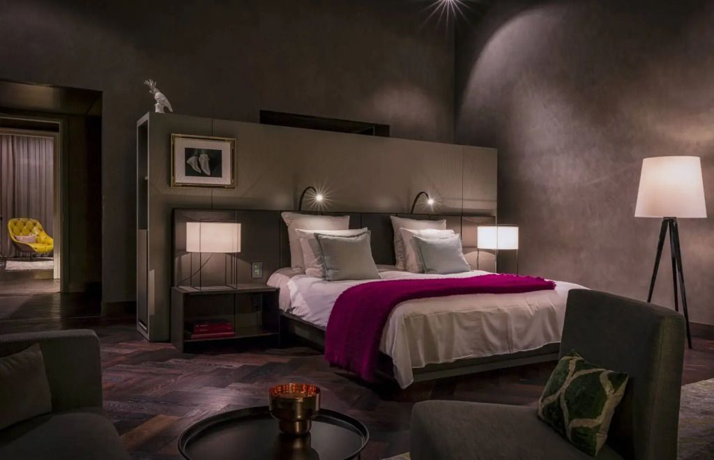 Luxuriöses Doppelzimmer mit stilvollen Lampen und Kunst an den Wänden